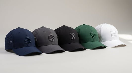 Six custom performance hats with laser-perforated ventilation, mesh panels and embroidered logos arranged on a grey studio surface