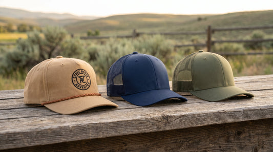 Three custom rope hats in tan, navy, and olive arranged on a rustic wooden surface for business wholesale ordering
