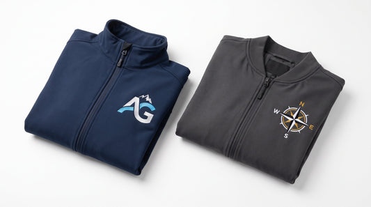 Embroidered company logo jackets flat lay, navy and charcoal soft shell and bomber jackets with left-chest logo detail