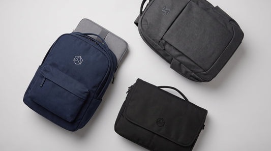 Custom embroidered corporate backpacks and a laptop messenger bag with abstract logo emblems, arranged for a business buying guide