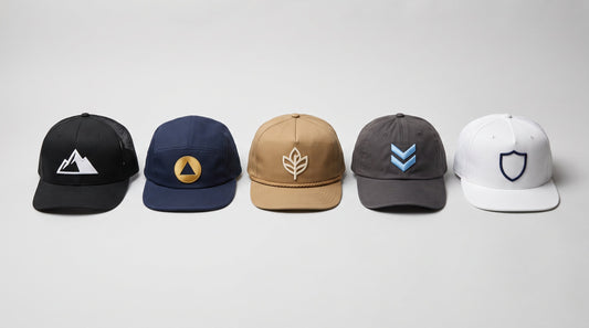 Five blank baseball cap styles laid out in a row - structured mesh trucker, five-panel, rope cap, unstructured dad cap and flat bill - showing the different logo areas available for custom hats with logo