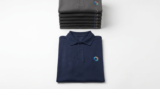 Custom polos with no minimum: one DTF printed navy polo in front of a stack of six embroidered polos