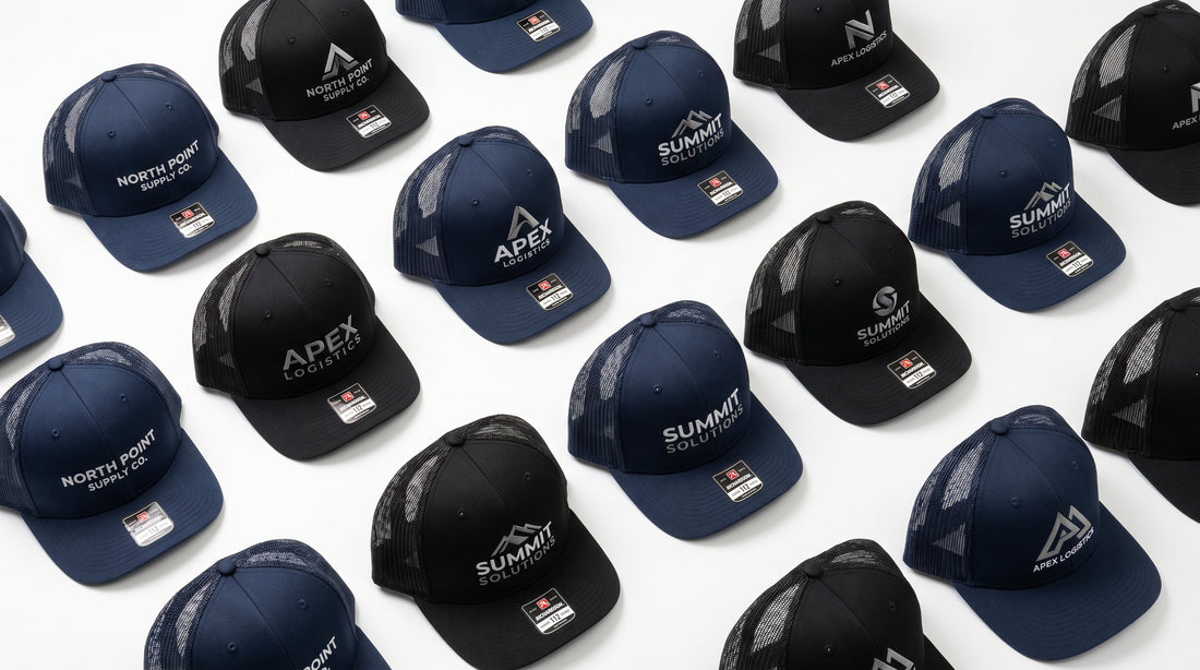 Custom embroidered trucker hats in navy and black arranged in a flat lay product photography style